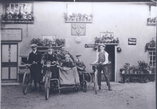 PHS041.02 Haylock family with bikes and side car in front of Three horseshoes lad second in from right is AubreyHaylock whose family ran pub (Deacon) Some of the Haylock family with bikes and side car in front of Three horseshoes lad second in from right is AubreyHaylock whose family ran pub | (Deacon)